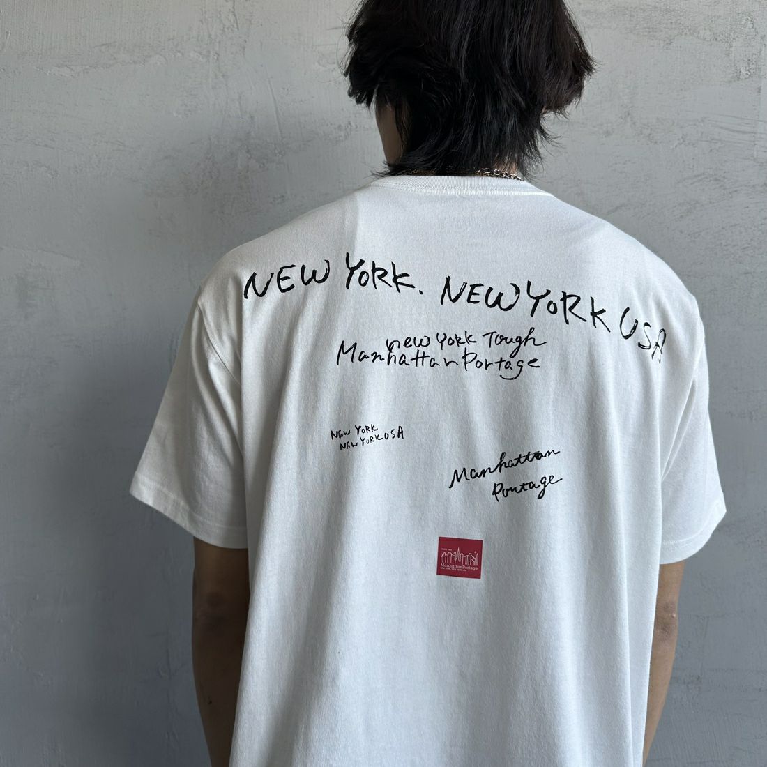 MANHATTAN PORTAGE [マンハッタンポーテージ] 別注 ランダムロゴ バックプリントTシャツ [25SSMP-IN66-JF] WHITE &&モデル身長：179cm 着用サイズ：L&&
