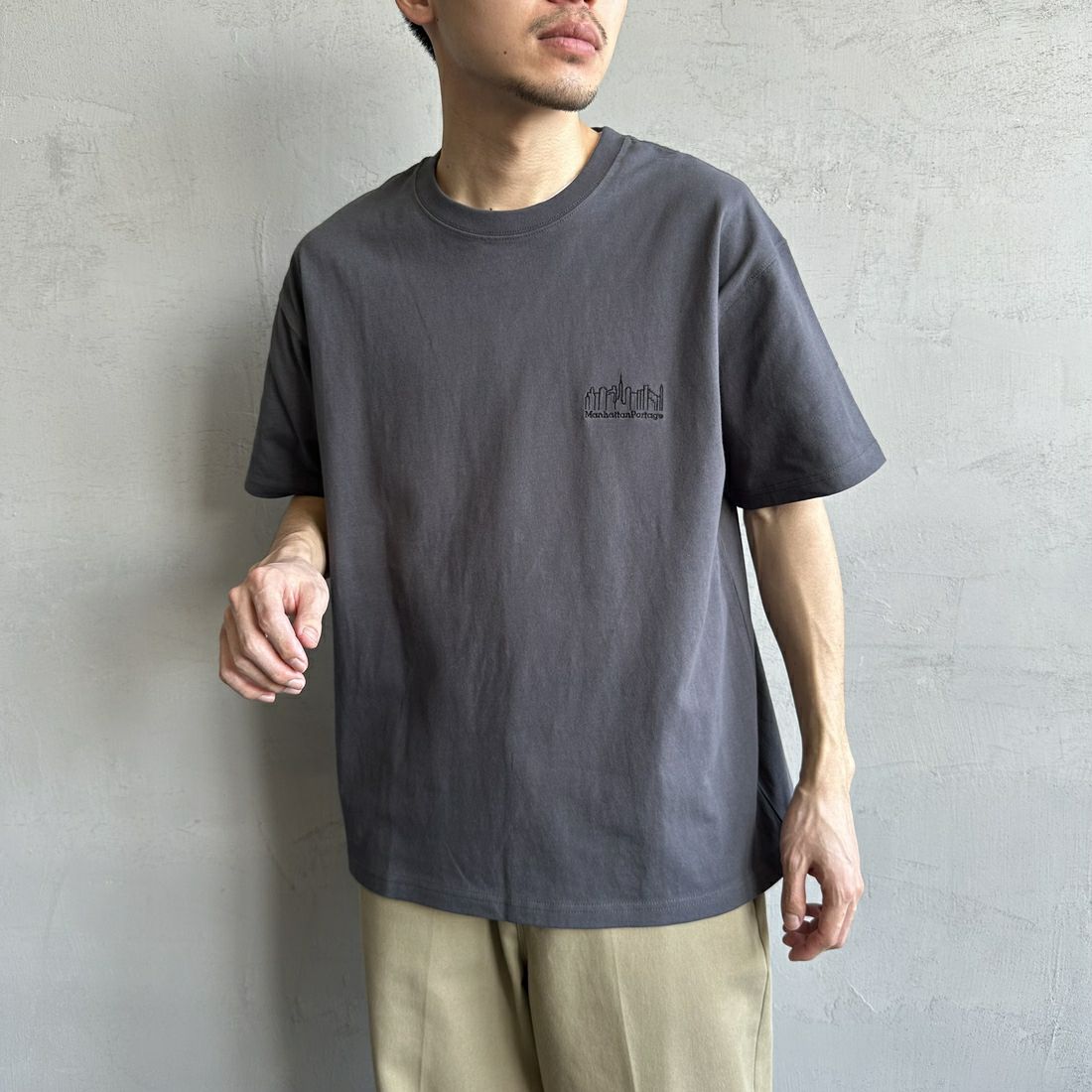 MANHATTAN PORTAGE [マンハッタンポーテージ] 別注 ランダムロゴ バックプリントTシャツ [25SSMP-IN66-JF] CHARCOAL &&モデル身長：168cm 着用サイズ：L&&