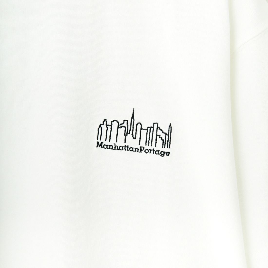 MANHATTAN PORTAGE [マンハッタンポーテージ] 別注 ランダムロゴ バックプリントTシャツ [25SSMP-IN66-JF] WHITE