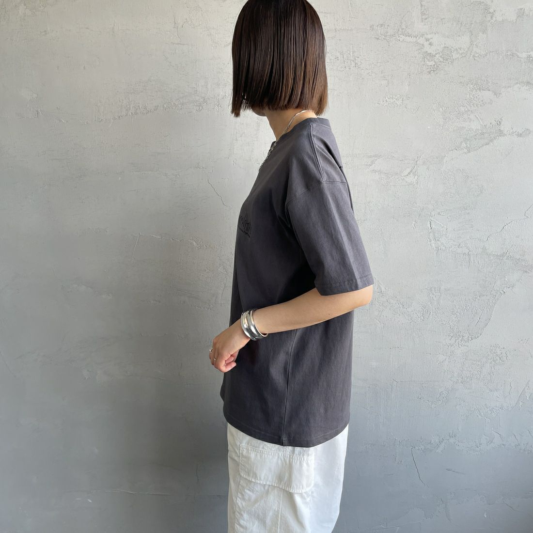 MANHATTAN PORTAGE [マンハッタンポーテージ] 別注 ランダムロゴ バックプリントTシャツ [25SSMP-IN66-JF] CHARCOAL &&モデル身長：159cm 着用サイズ：S&&