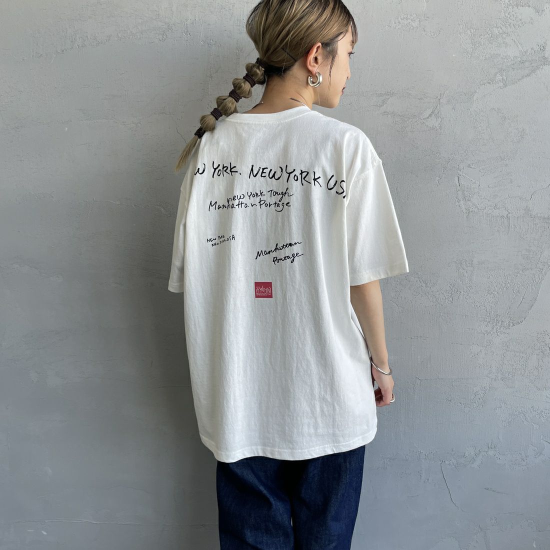 MANHATTAN PORTAGE [マンハッタンポーテージ] 別注 ランダムロゴ バックプリントTシャツ [25SSMP-IN66-JF] WHITE &&モデル身長：150cm 着用サイズ：S&&