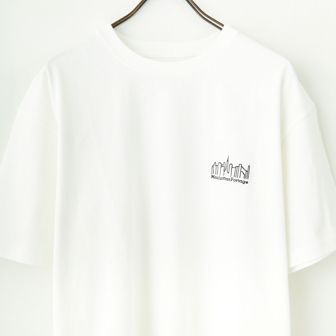 MANHATTAN PORTAGE [マンハッタンポーテージ] 別注 ランダムロゴ バックプリントTシャツ [25SSMP-IN66-JF] WHITE