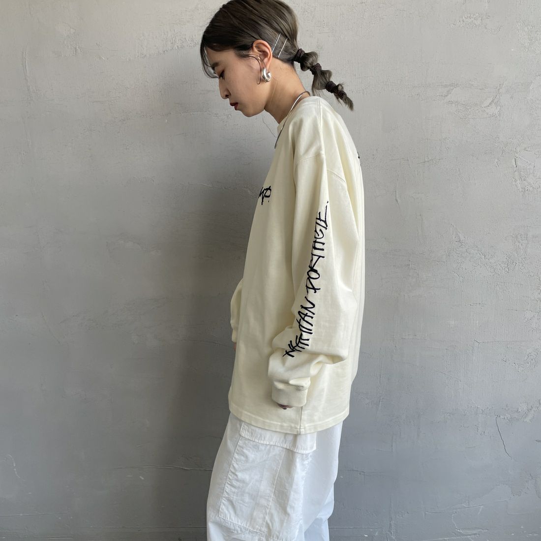 MANHATTAN PORTAGE [マンハッタンポーテージ] 別注 ピグメント染め 手書き風バックロゴ刺繍ロンT [25SSMP-IN64-JF] IVORY &&モデル身長：150cm 着用サイズ：S&&