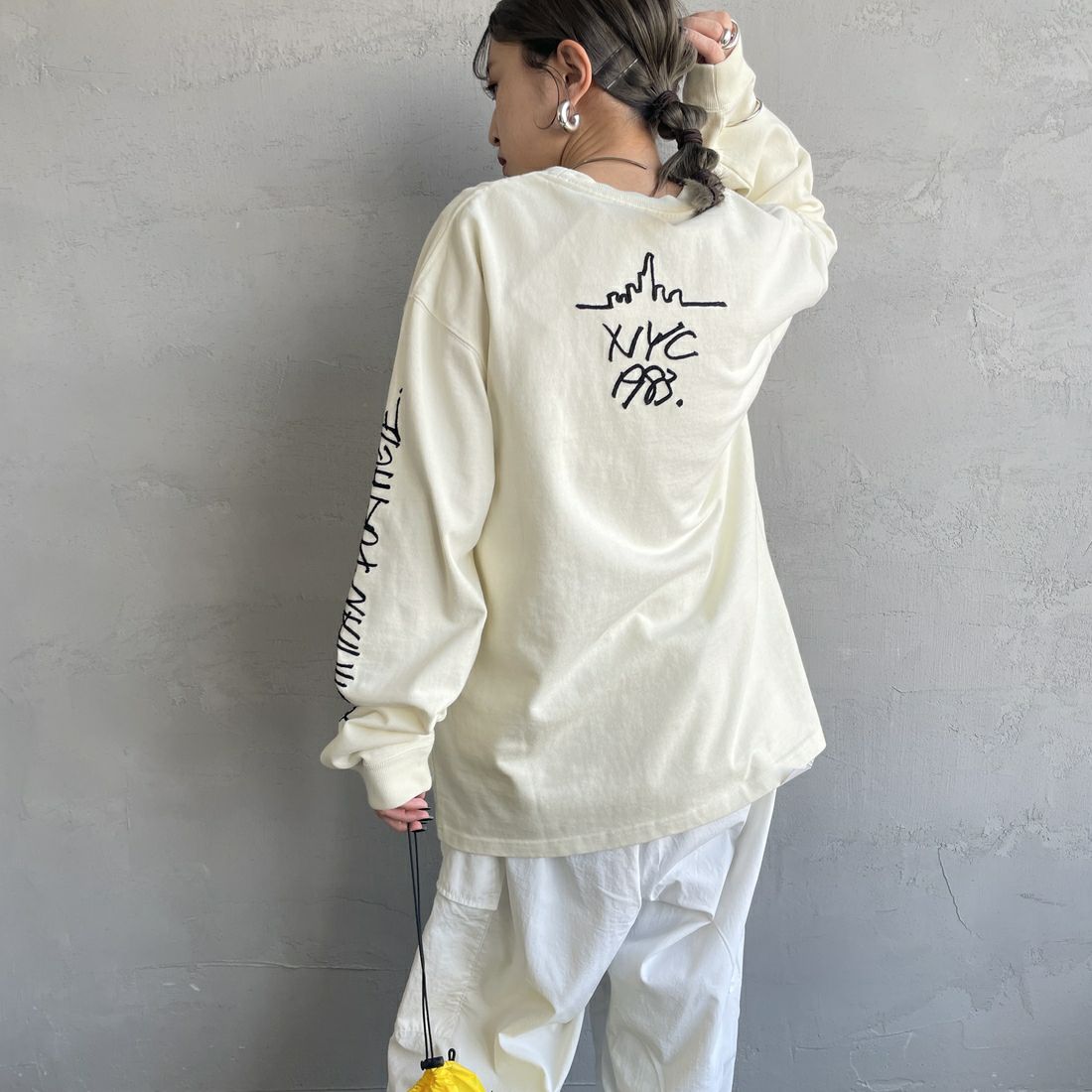 MANHATTAN PORTAGE [マンハッタンポーテージ] 別注 ピグメント染め 手書き風バックロゴ刺繍ロンT [25SSMP-IN64-JF] IVORY &&モデル身長：150cm 着用サイズ：S&&