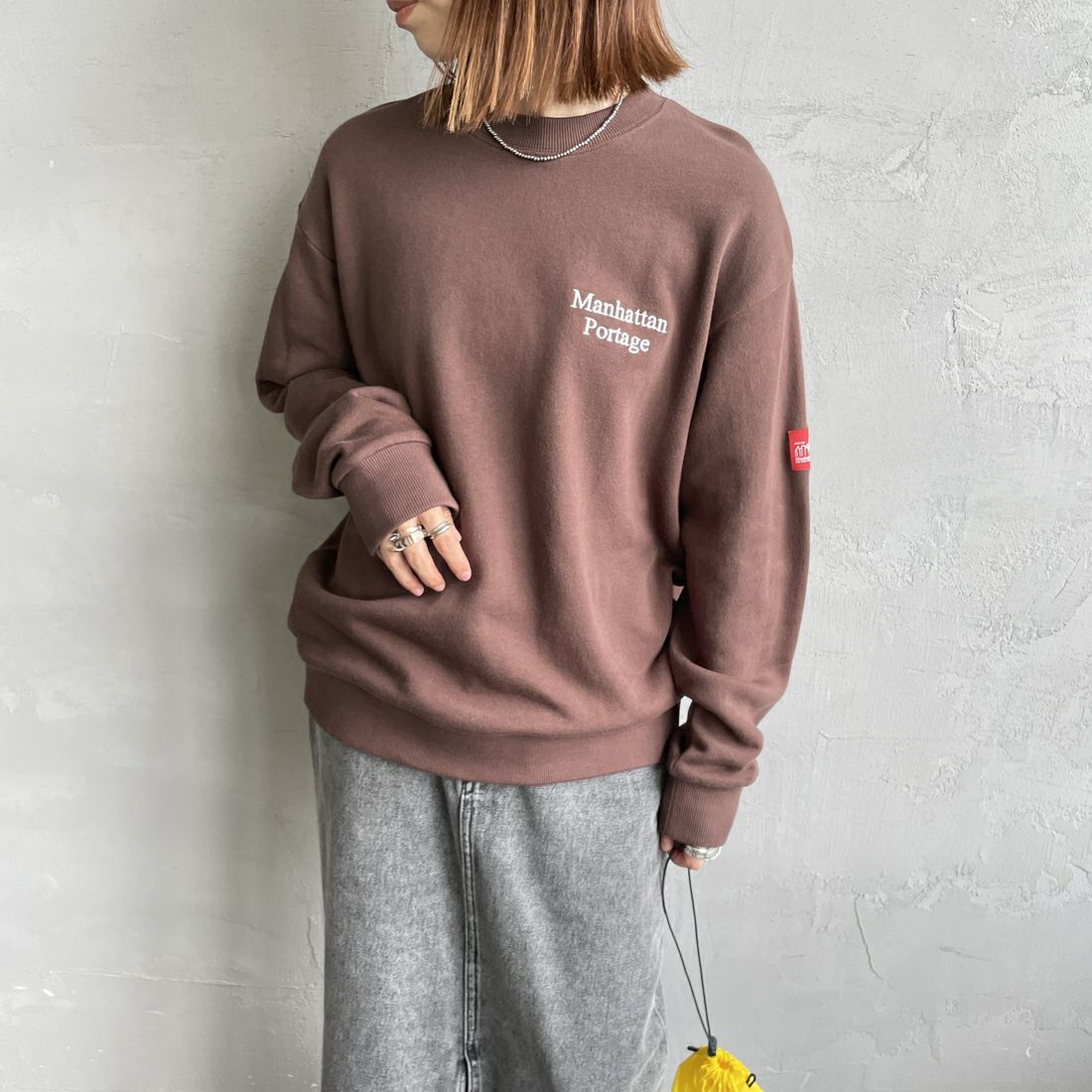 MANHATTAN PORTAGE [マンハッタンポーテージ] 別注 手書き風バック刺繍クルーネックスウェット [25FWMP-IN69-JF] D.BROWN &&モデル身長：158cm 着用サイズ：S&&