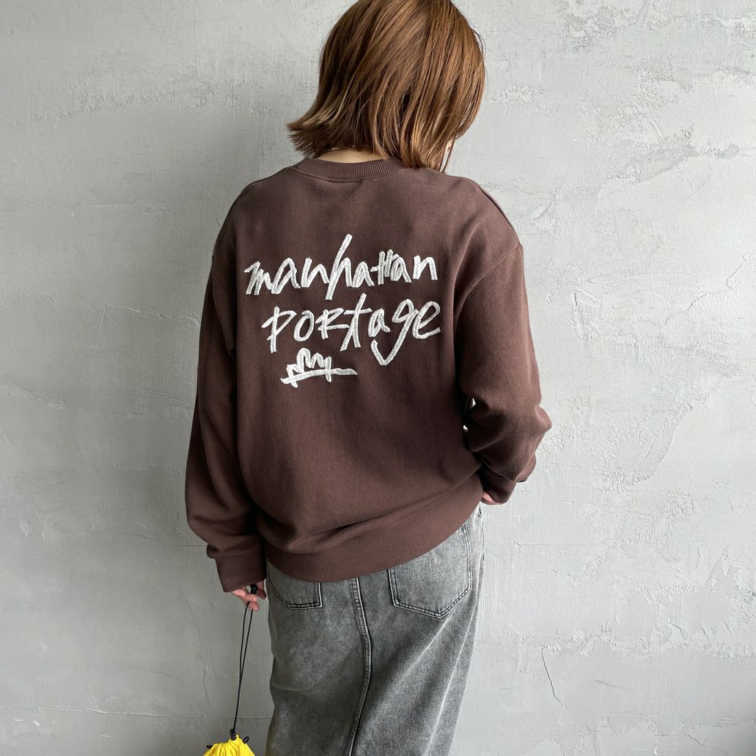 MANHATTAN PORTAGE [マンハッタンポーテージ] 別注 手書き風バック刺繍クルーネックスウェット [25FWMP-IN69-JF] D.BROWN &&モデル身長：158cm 着用サイズ：S&&