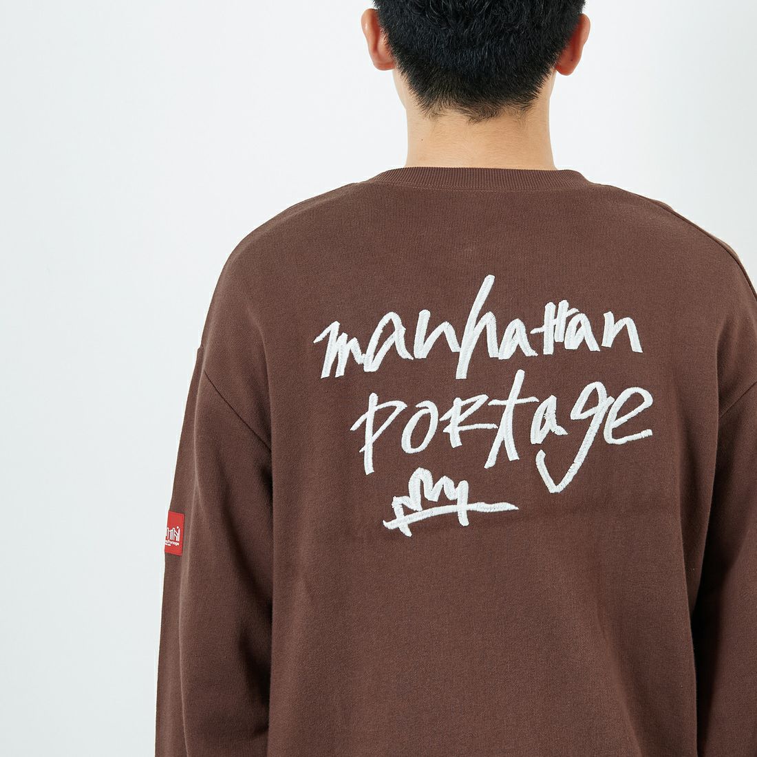 MANHATTAN PORTAGE [マンハッタンポーテージ] 別注 手書き風バック刺繍クルーネックスウェット [25FWMP-IN69-JF] D.BROWN &&モデル身長：168cm 着用サイズ：L&&