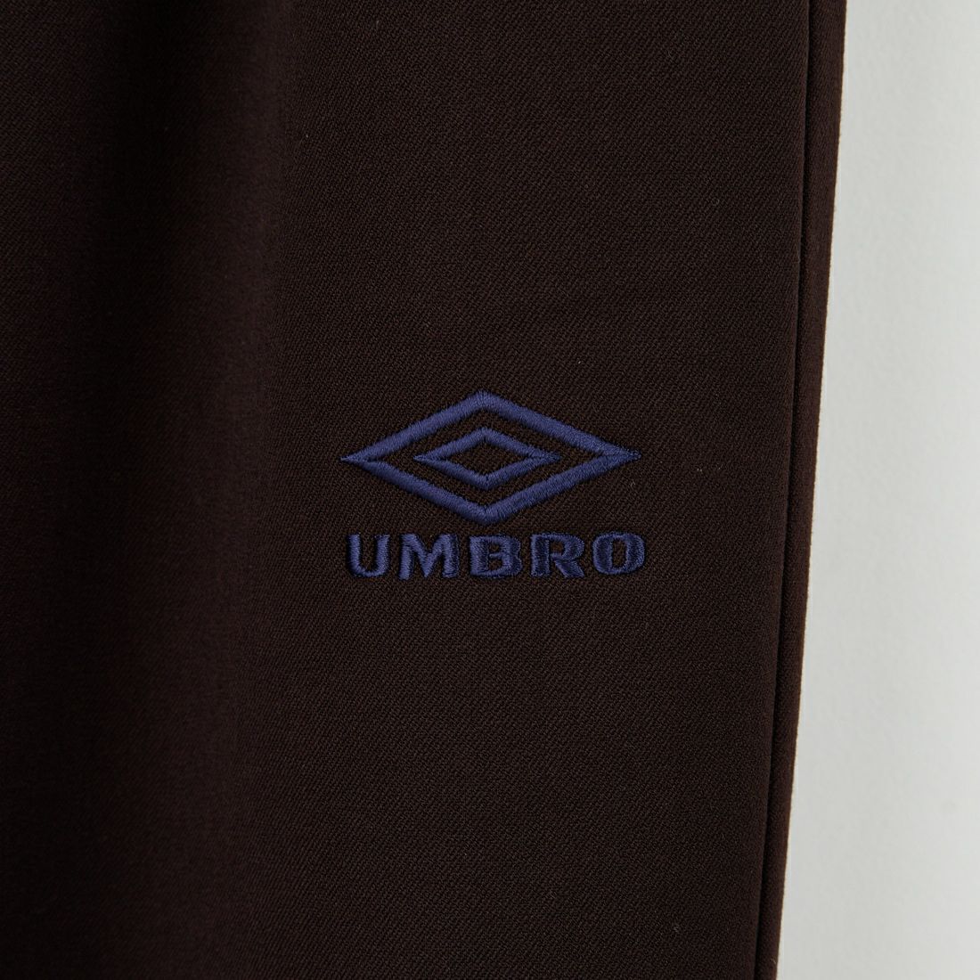 UMBRO [アンブロ] 別注 ワンポイント刺繍ロゴ トラックパンツ [KBT126-NK-PT2-MS-JF] BROWN