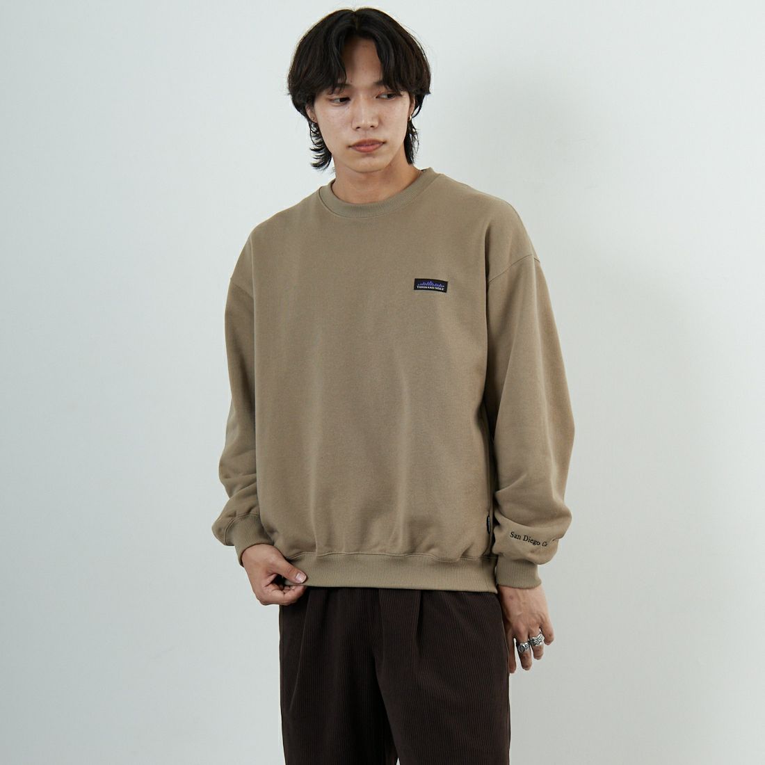 THOUSAND MILE [サウザンド マイル] 別注 ワンポイントロゴ クルーネックスウェット [TM252UK50510-JF] 23 BEIGE &&モデル身長：179cm 着用サイズ：M&&